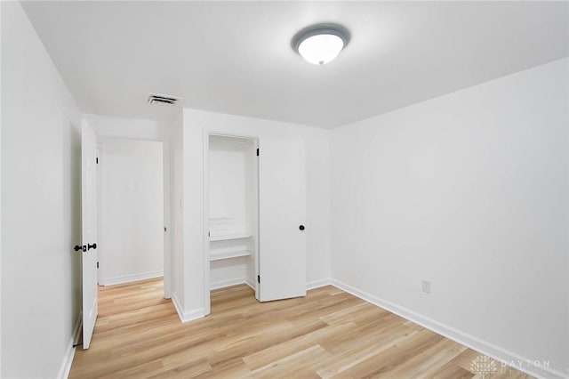 unfurnished bedroom featuring light wood-style floors, visible vents, and baseboards