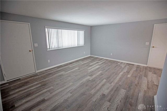 empty room featuring baseboards and wood finished floors