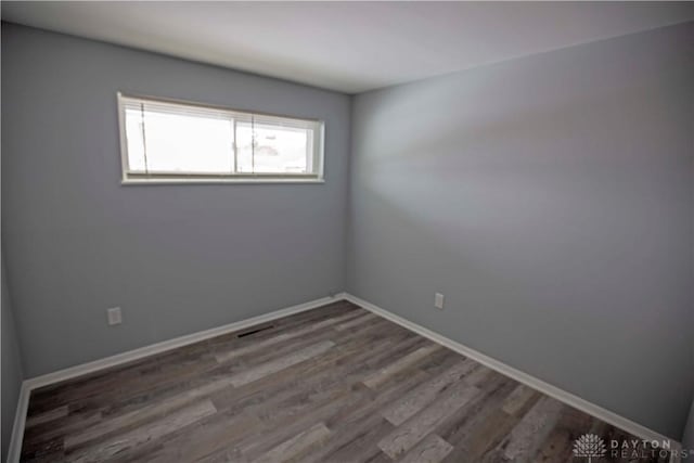 empty room with baseboards and wood finished floors