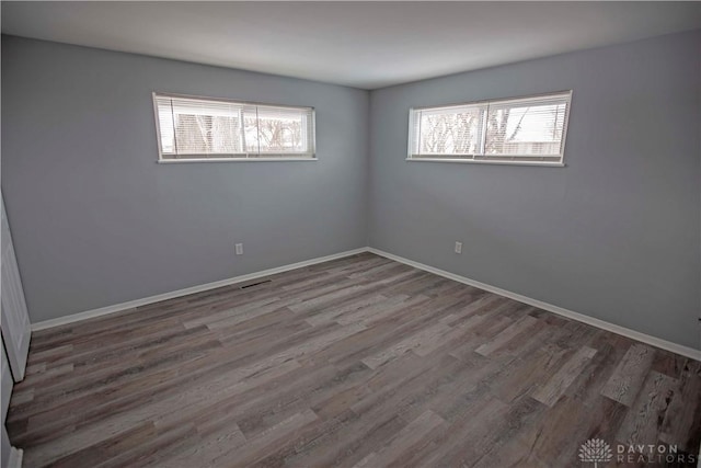 empty room with baseboards and wood finished floors