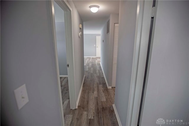 corridor with visible vents, baseboards, and wood finished floors