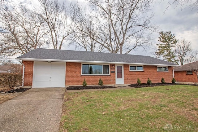 single story home featuring a shingled roof, concrete driveway, an attached garage, a front yard, and brick siding