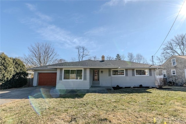 single story home featuring an attached garage, driveway, roof with shingles, a chimney, and a front yard