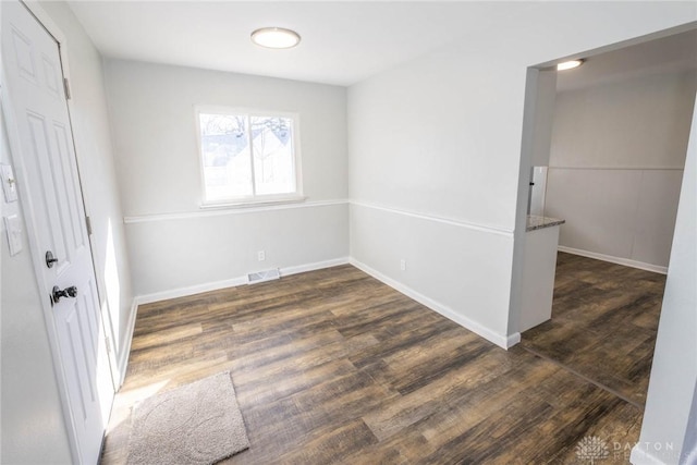 unfurnished bedroom featuring dark wood-type flooring, visible vents, and baseboards