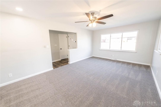 unfurnished room featuring ceiling fan, baseboards, and dark colored carpet