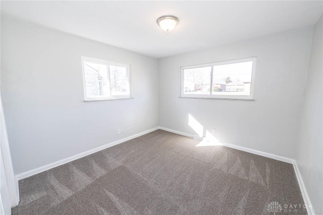 carpeted spare room with baseboards