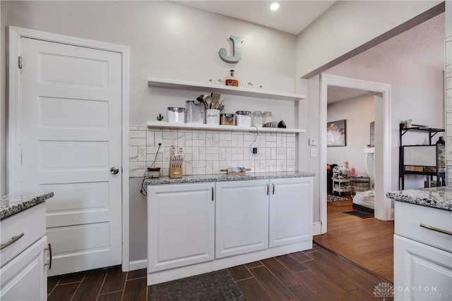 bar with tasteful backsplash and wood finish floors