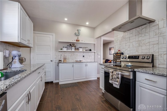 kitchen with light stone counters, dark wood-style floors, appliances with stainless steel finishes, white cabinets, and exhaust hood