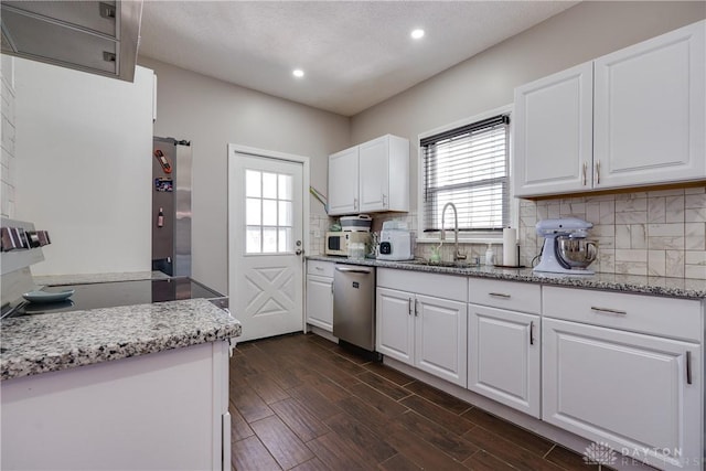 kitchen with white cabinets, dark wood-style flooring, a sink, stainless steel appliances, and a wealth of natural light