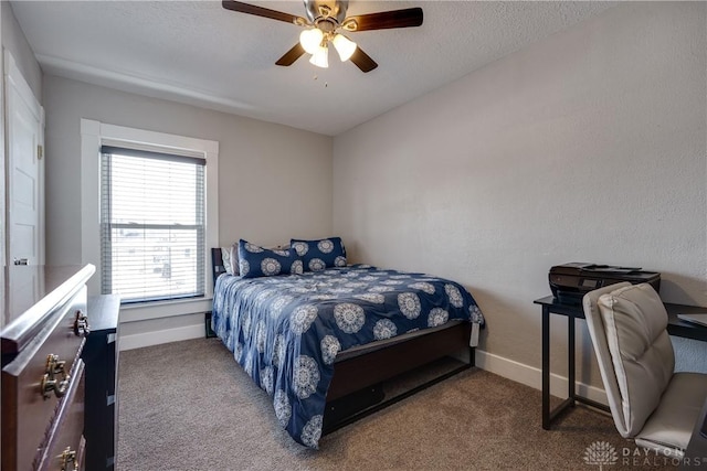 carpeted bedroom featuring a textured ceiling, a ceiling fan, and baseboards