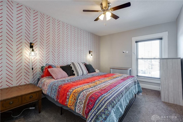 bedroom with an accent wall, ceiling fan, carpet floors, and wallpapered walls