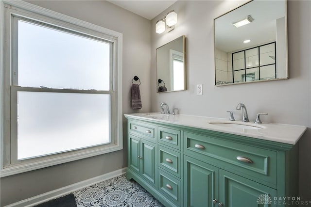 full bathroom featuring double vanity, tile patterned flooring, baseboards, and a sink