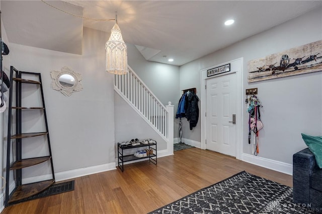 entrance foyer featuring stairs, wood finished floors, and baseboards