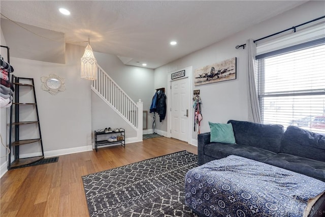 living area with stairs, recessed lighting, wood finished floors, and baseboards