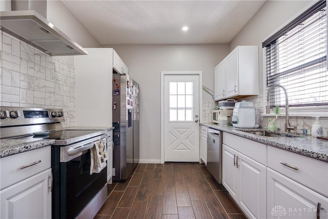 kitchen with range hood, dark wood finished floors, stainless steel appliances, white cabinetry, and a sink