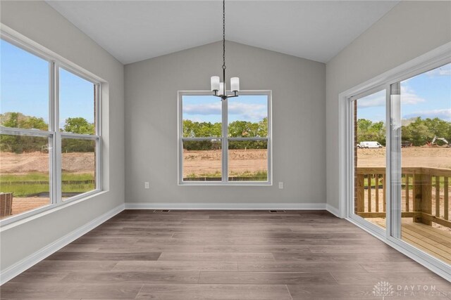 2881 Sky Crossing Dr Unit 55, Beavercreek, OH 45434 - unfurnished dining area with a chandelier, plenty of natural light, wood finished floors, vaulted ceiling, and baseboards