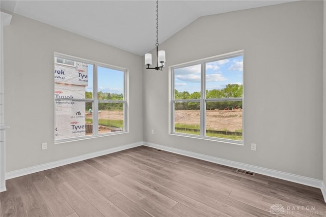 2881 Sky Crossing Dr Unit 55, Beavercreek, OH 45434 - spare room featuring a chandelier, vaulted ceiling, wood finished floors, and baseboards