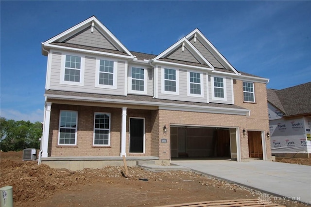 2881 Sky Crossing Dr Unit 55, Beavercreek, OH 45434 - view of front facade with a garage, driveway, a porch, cooling unit, and brick siding