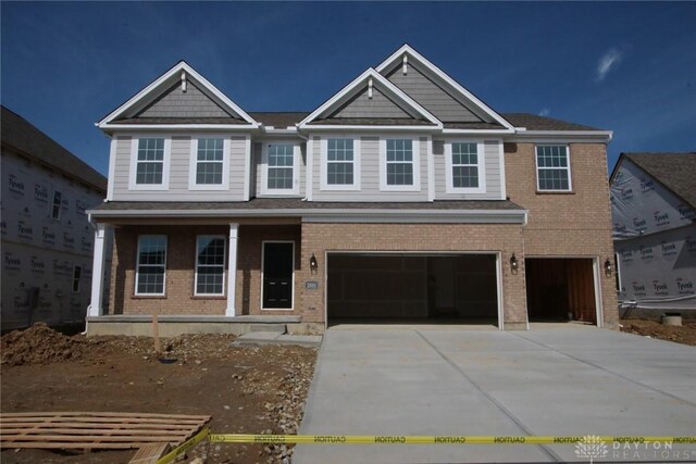 2881 Sky Crossing Dr Unit 55, Beavercreek, OH 45434 - view of front of property with an attached garage, driveway, brick siding, and a porch