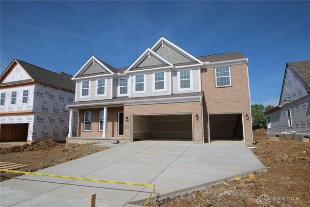2881 Sky Crossing Dr Unit 55, Beavercreek, OH 45434 - view of front of property with a garage, brick siding, concrete driveway, and covered porch