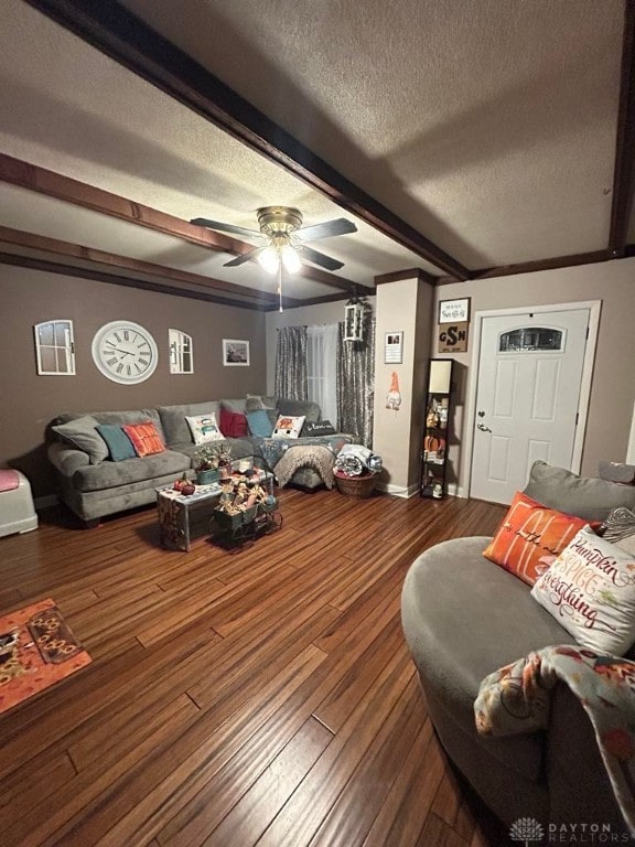 living room with a textured ceiling, beamed ceiling, wood finished floors, and a ceiling fan