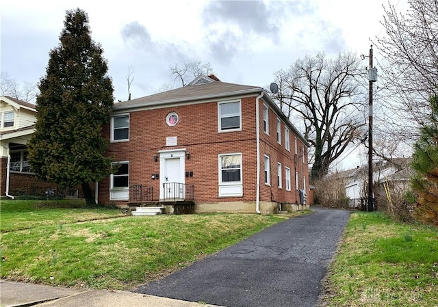 view of front of home with a front lawn and brick siding