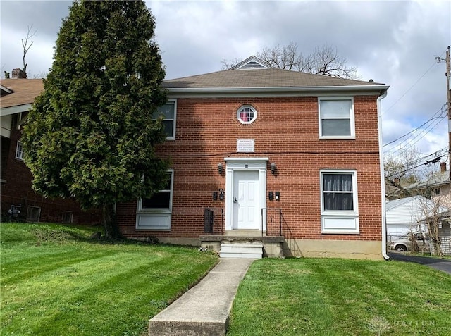 view of front of property featuring a front yard and brick siding