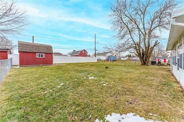 view of yard with a storage shed, a fenced backyard, and an outdoor structure