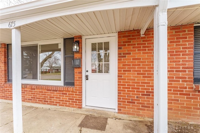 doorway to property with brick siding