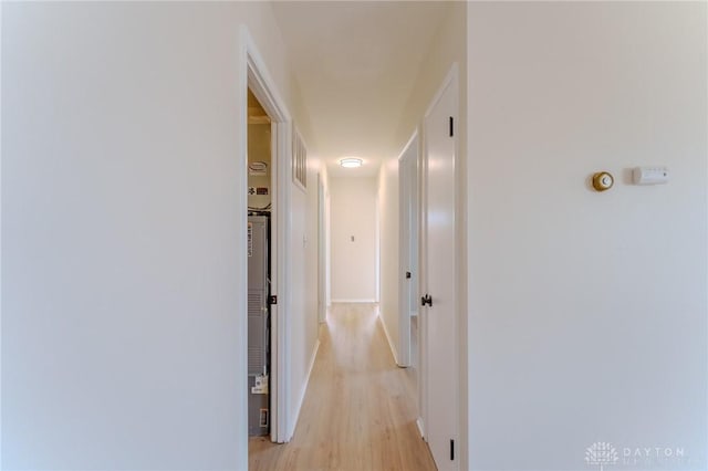 hall featuring light wood-style flooring and baseboards