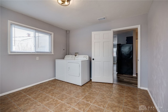 laundry room featuring visible vents, washing machine and dryer, tile patterned flooring, laundry area, and baseboards