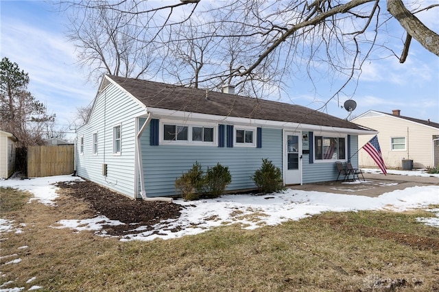 ranch-style home with a yard, cooling unit, and fence