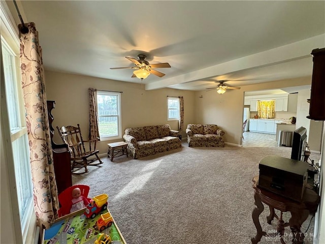 carpeted living area featuring ceiling fan and baseboards