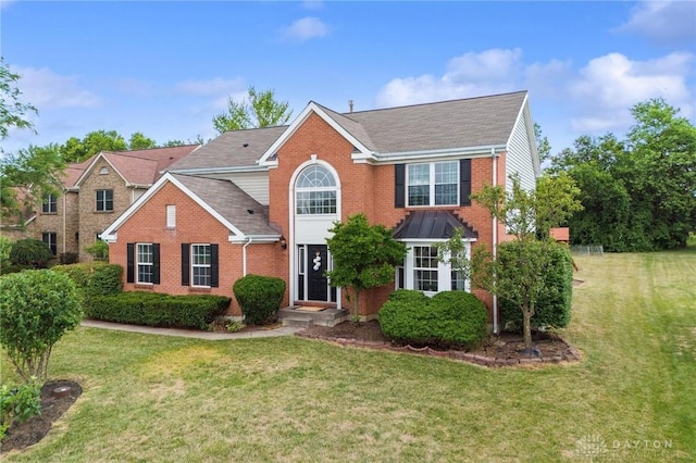 view of front of home featuring a front lawn and brick siding