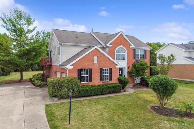 view of front of property with a garage, driveway, brick siding, and a front lawn