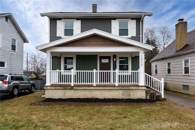 view of front of house featuring board and batten siding, covered porch, and a front lawn