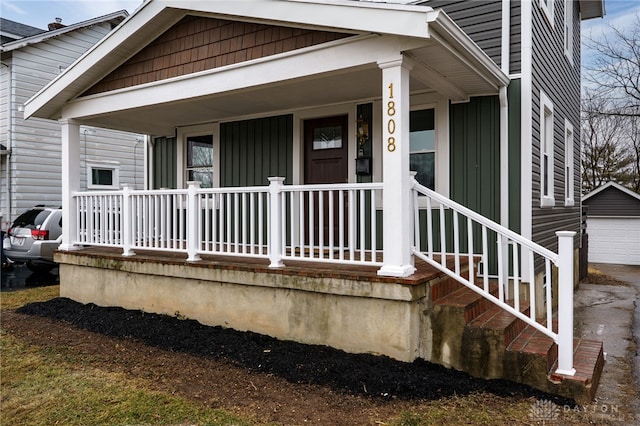 view of exterior entry with covered porch and a detached garage