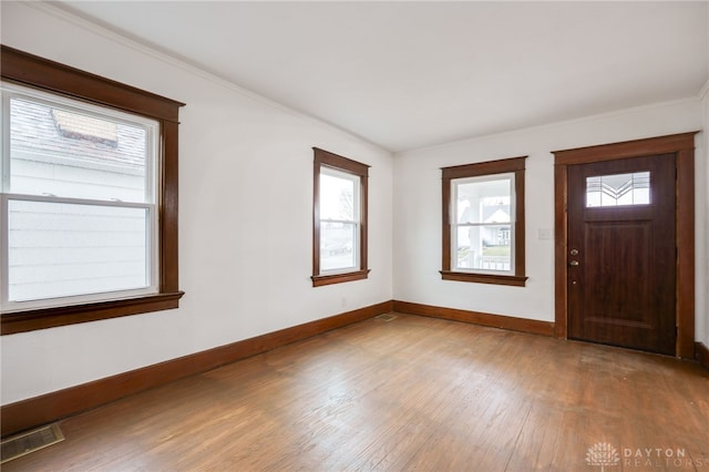 entryway featuring visible vents, crown molding, baseboards, and wood finished floors