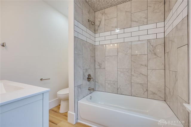 full bathroom with shower / bathtub combination, toilet, wood finished floors, vanity, and baseboards