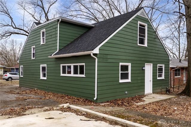 view of side of property with roof with shingles