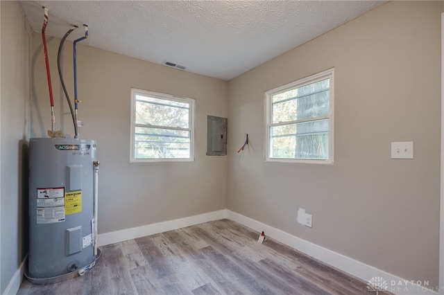 utilities featuring electric panel, water heater, and visible vents