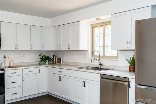 kitchen featuring white cabinetry, appliances with stainless steel finishes, light countertops, and a sink