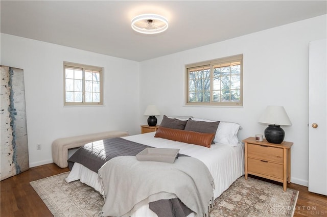 bedroom featuring baseboards and dark wood-style flooring