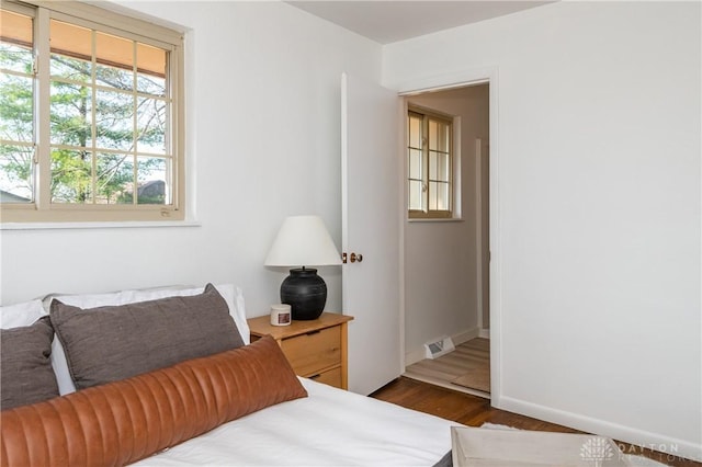 bedroom featuring baseboards, visible vents, and dark wood finished floors