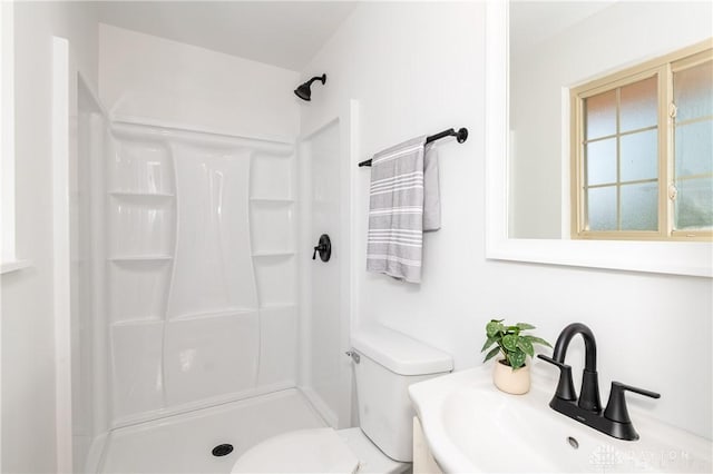 full bathroom featuring a shower, a sink, and toilet