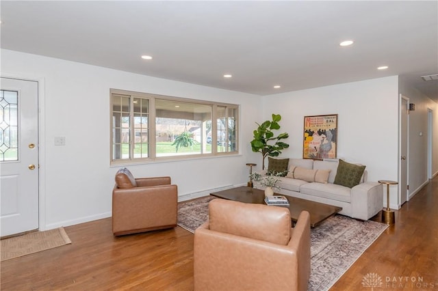 living area with recessed lighting, visible vents, baseboards, and wood finished floors