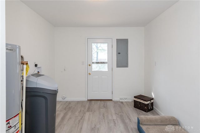 laundry area with light wood-type flooring, water heater, electric panel, and baseboards