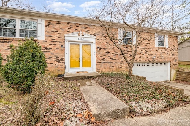 view of front of property featuring a garage, driveway, and brick siding