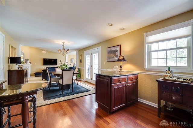 dining room featuring dark wood-style floors, baseboards, a notable chandelier, and french doors