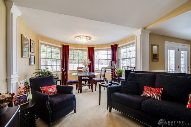 living room featuring light carpet and ornate columns